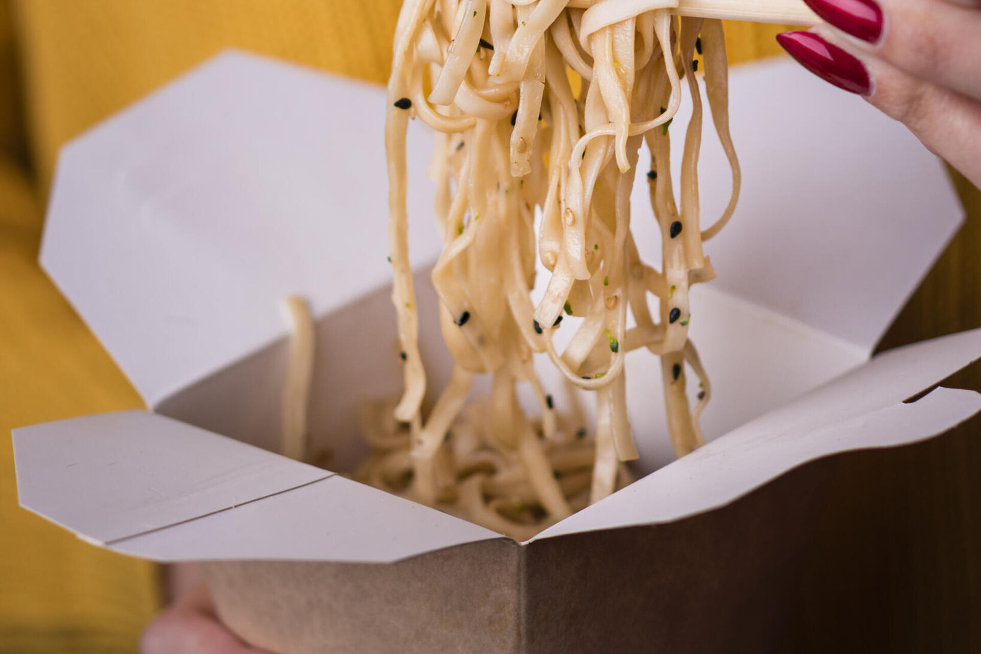 woman-holding-noodles-chopsticks
