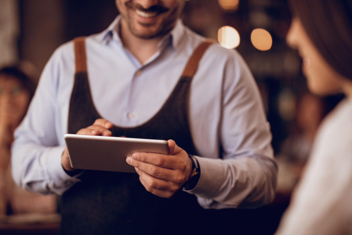 closeup-waiter-taking-order-touchpad-while-talking-guest-pub